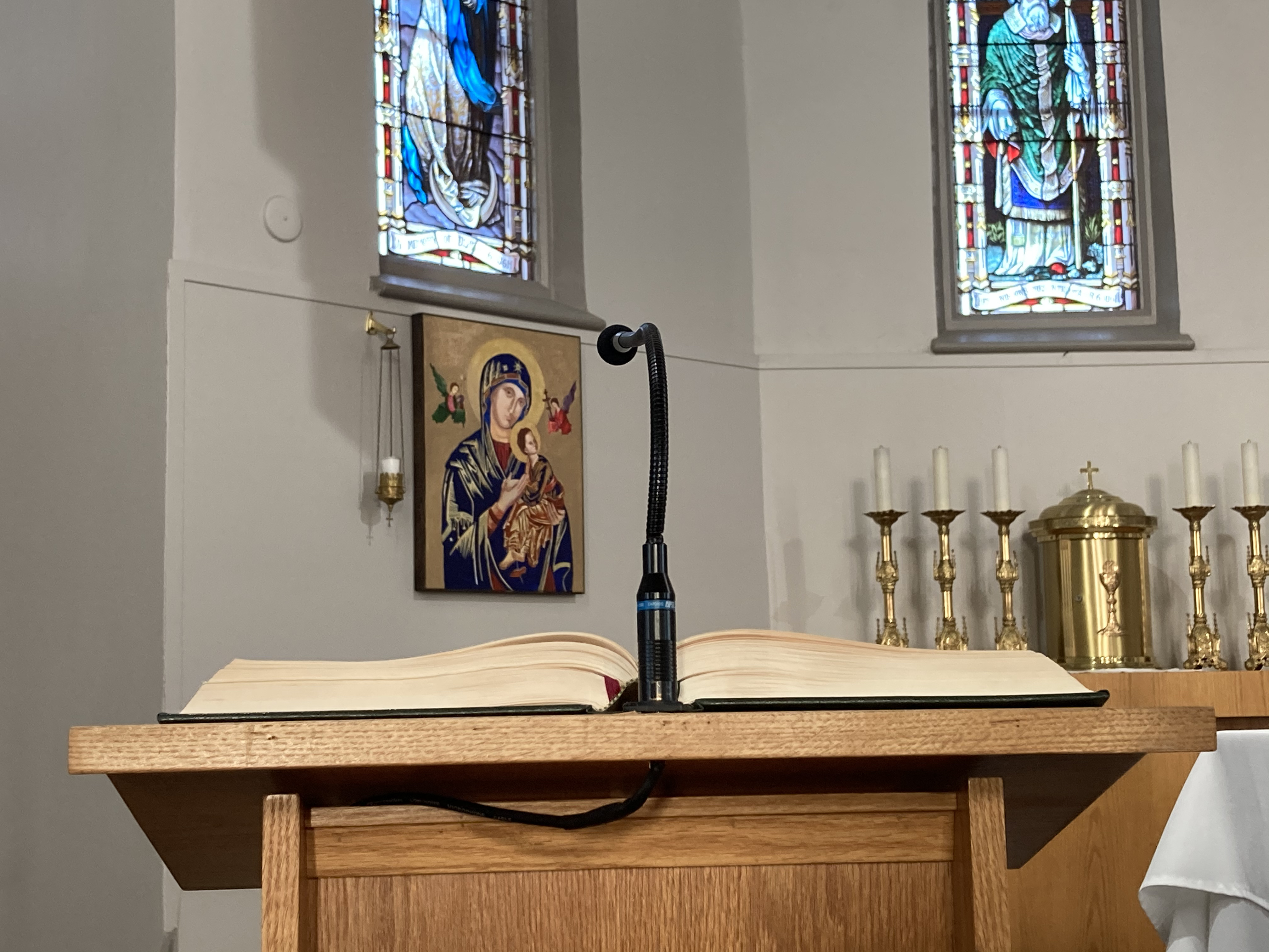 Close up image of top of lectern, Lectionary open and black microphone centred with the lectionary