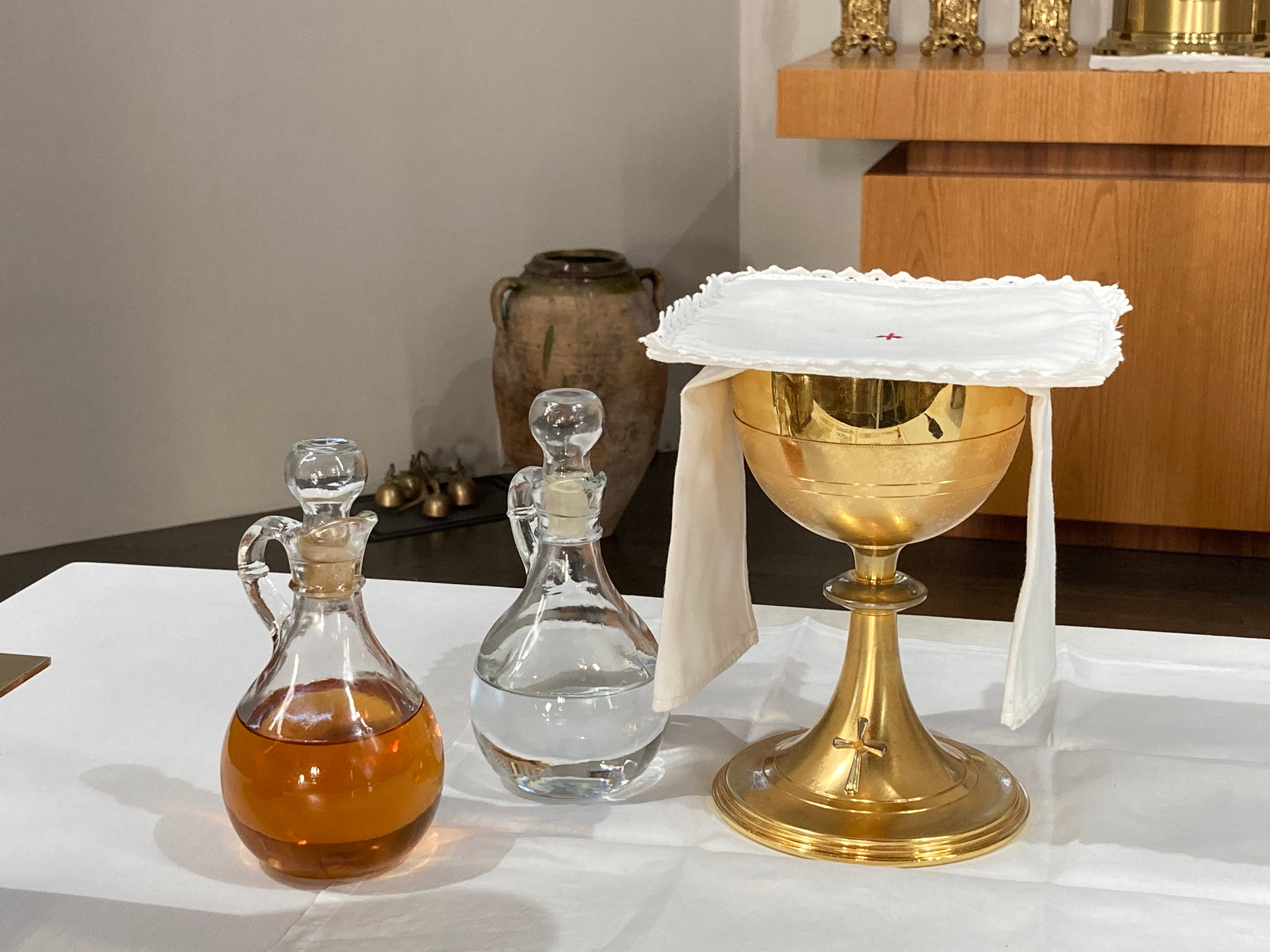 Chalice assembly and water and wine placed on top of altar
