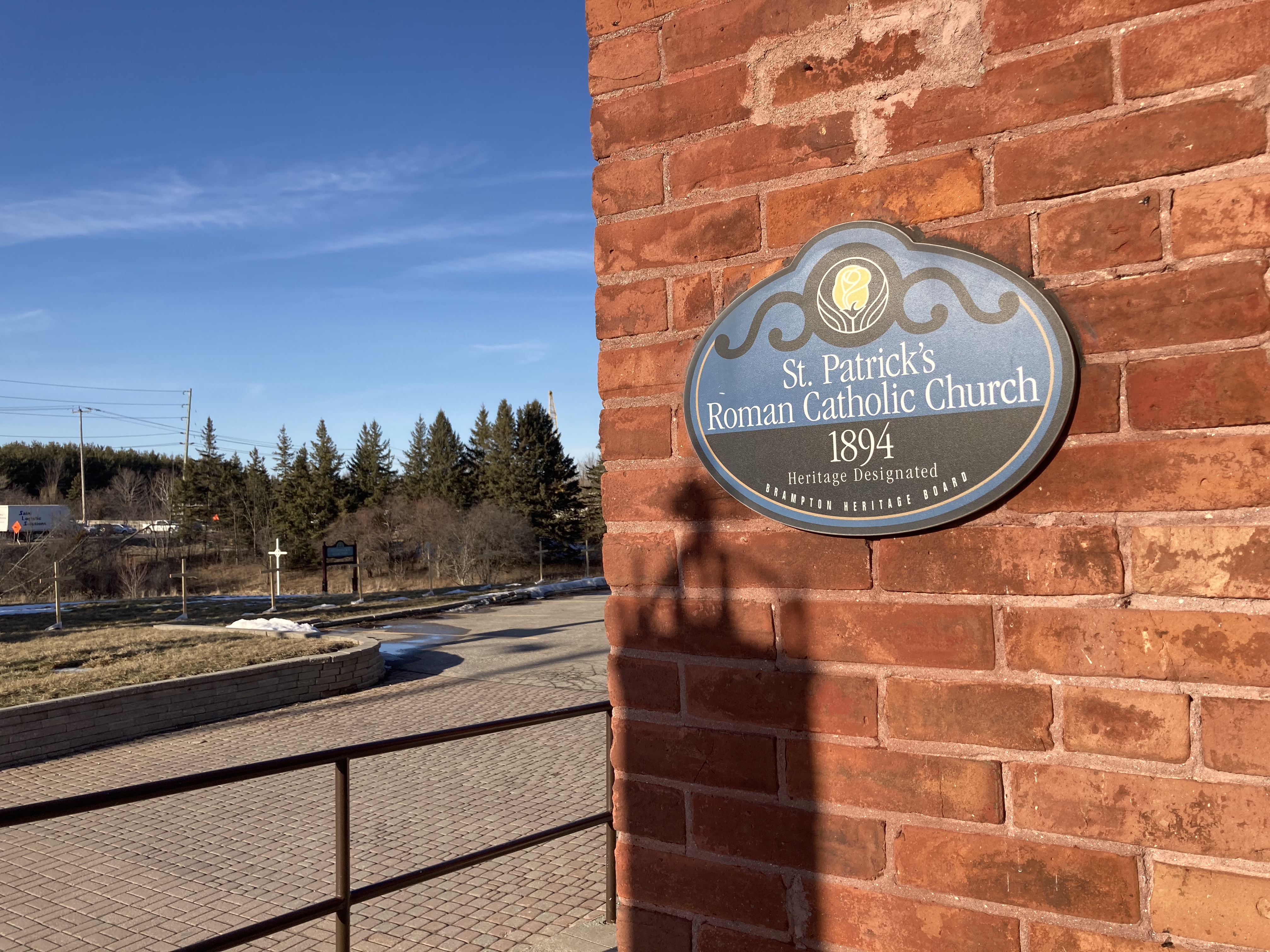Photo of Brampton historical site sign located at front of church building on a red brick wall